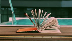 An open book is fanned out on a wooden floor near a pool. The paper book rests on a wooden surface set against a background of a blue water, perfect for reading. Summer vacatios. - Powered by Shutterstock - Get 15% off with code: PIKWIZARD15