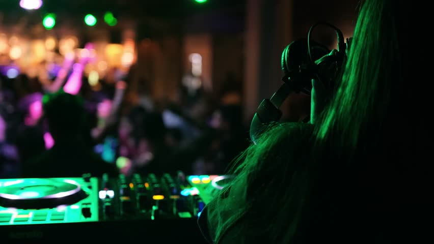 Dynamic DJ performance in a nightclub. Feel the electric atmosphere and dance energy of the evening