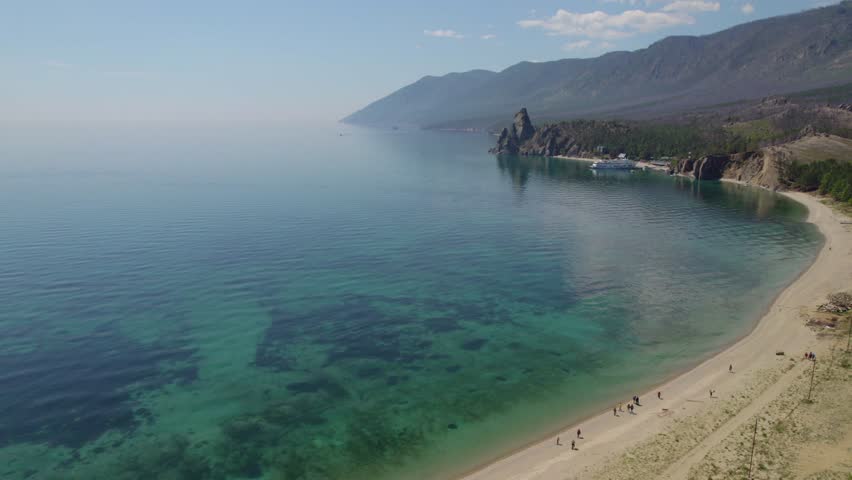 Sandy bay on a summer day. Beautiful view of Cape Kolokolny, sandy beach, clear water of Lake Baikal. 
