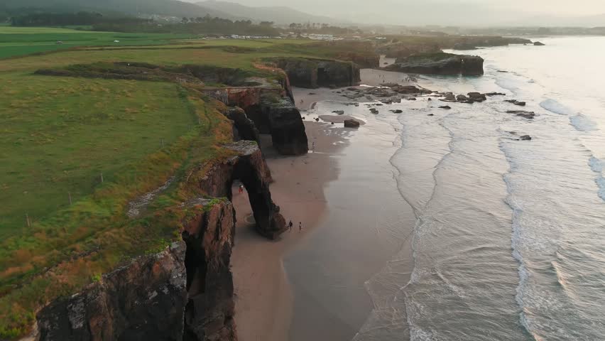 Amazing aerial view of the Playa de Las Catedrales beach in Galicia region at sunset, northern Spain. Beautiful cliff formations on famous Cathedral Beach, Cantabrian Coast 