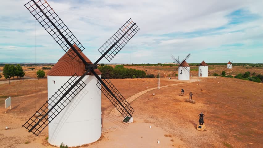 Aerial view of the historic windmills of Mota del Cuervo, Castilla-La Mancha, Spain. Old historic windmills of Don Quixote character on the hills in evening light. Molinos de Viento de Mota del Cuervo