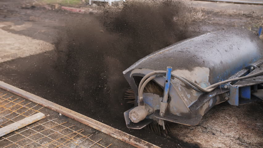 Sweeper machine clearing dirt and debris at construction site