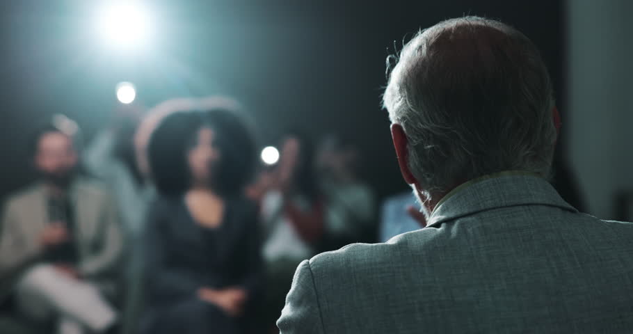 Press conference, speaker and person with motivation for crowd, talking or public speaking on stage. Presentation, back and politician with announcement for audience, speech and official event