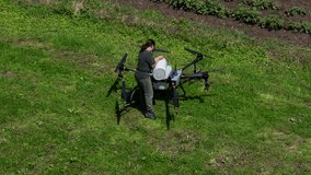 Aerial view of a female farmer changing a battery in a large agricultural drone in a green field, showcasing modern smart farming, drone technology and precision agriculture innovation  - Powered by Shutterstock - Get 15% off with code: PIKWIZARD15