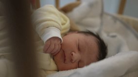 Newborn baby peacefully sleeping in a crib with a yellow onesie, capturing a serene moment of rest and innocence, perfect for family, parenting, and healthcare themes in stock imagery - Powered by Shutterstock - Get 15% off with code: PIKWIZARD15