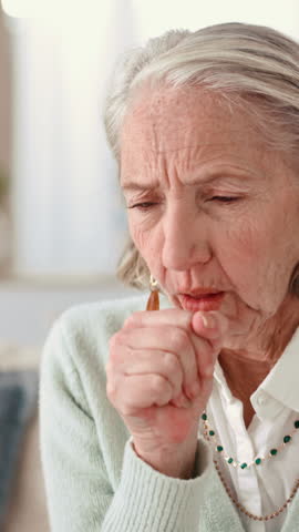 Elderly, sick woman or cough with illness for asthma, bronchitis or lung disease on sofa at home. Senior, female person or chronic flu with symptoms, sinus or virus for respiratory infection at house