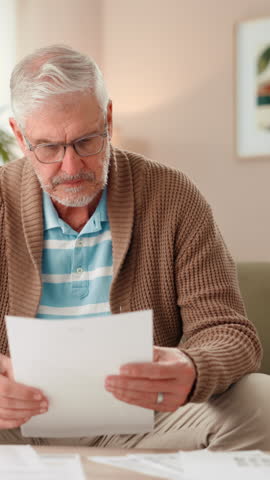 Senior man, reading and documents at house for financial review, payment statement and savings. Elderly person, paperwork and mortgage expenses, pension balance and finance invoice of retirement fund