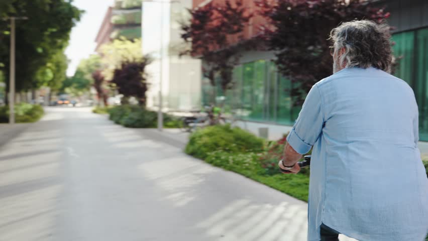 Healthy, active, retired senior man enjoying bicycle ride in the modern city