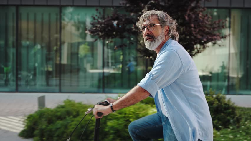 Healthy, active, retired senior man enjoying bicycle ride in the modern city