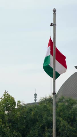 Vertical Slow motion of the Hungarian flag gently swaying in Budapest. Captures a serene moment of national pride against the backdrop of the city.