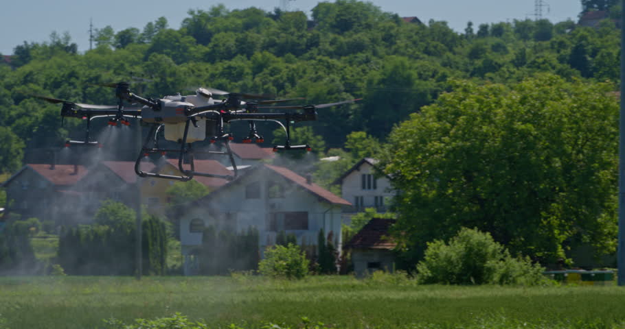 Aerial drone flying over a cultivated farm field during a crop monitoring or spraying mission, highlighting advanced agricultural technology and precision farming techniques in rural settings.