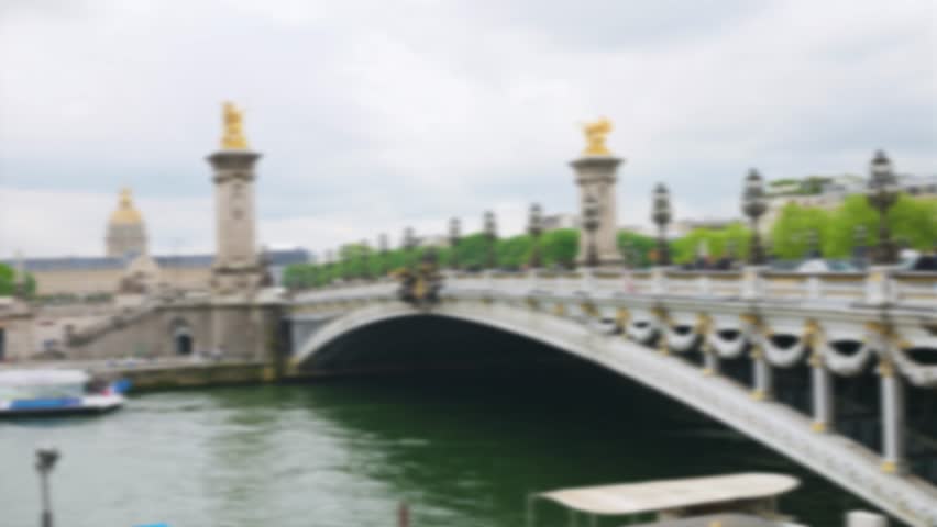 View of the the Pont Alexandre III bridge over the Seine River and the House of Invalides from the right bank. Out of focus. Paris, France.