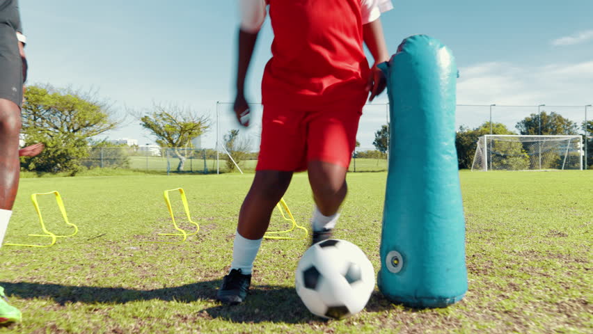 Agility, dribble or soccer with child and coach on field for ball control, exercise inflatable or training. Fitness, kid or practice with football player on sports pitch for drill, skill or technique - Powered by Shutterstock - Get 15% off with code: PIKWIZARD15