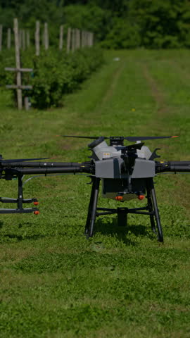 Vertical aerial footage of a drone in flight over a cultivated farm field, capturing a crop spraying or monitoring mission that showcases smart farming, agri-tech, and precision agriculture in rural