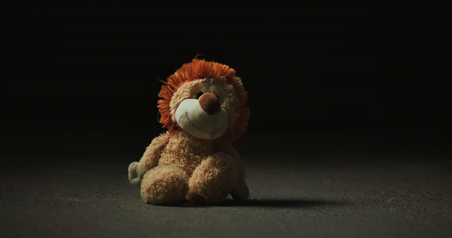 Abandoned, lost and adoption fail with toy in studio for loneliness, depression and grief. Foster care rejection, stuffed animal and mental health with lion on dark background for fear and mourning