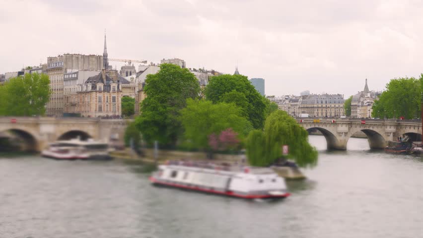 View from the right bank of the Seine on a ferry with tourists sailing along the Ile de la Cite, the Pont Neuf bridge, cathedral church Notre-Dame de Paris, Place du Quebec in the 1st arrondissement. 