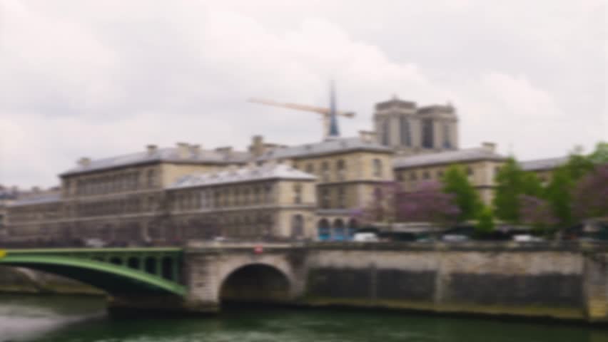 View of the Seine river, Pont Notre Dame bridge and cathedral church Notre-Dame de Paris on a cloudy spring day in Paris, France. Out of focus.
