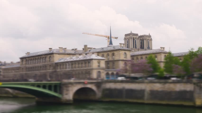 View of the Seine river, Pont Notre Dame bridge and cathedral church Notre-Dame de Paris on a cloudy spring day in Paris, France. Out of focus.