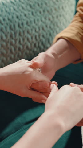 Home, holding hands and couple with love, closeup and bonding together with support. Apartment, man and woman on sofa, romance and kindness with empathy, relationship and marriage with gratitude