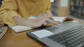 Man studying at home using laptop, close up view. Higher institution student sits at table with device, prepare homework, learns theory, make notes in copybook, researching, engaged in online lesson. - Powered by Shutterstock - Get 15% off with code: PIKWIZARD15