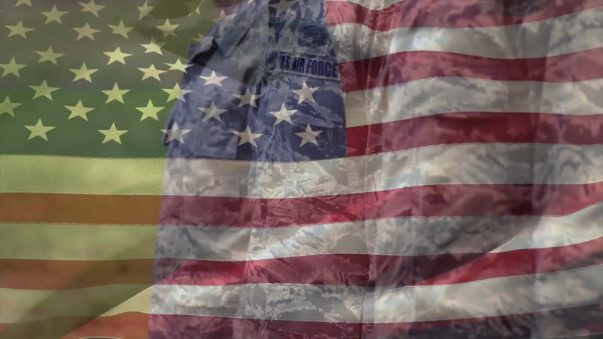 Two US airmen aligning and gazing upward as drifting flag overlay moves in military ceremony. Military, discipline, patriotism, unity, valor, outdoor, solemn