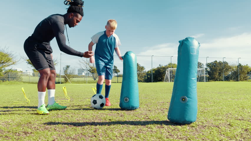 Agility, drill or soccer with coach and kid on field for ball control, exercise or training. Children, dribbling and practice with football player on sports pitch for fitness, skill or technique