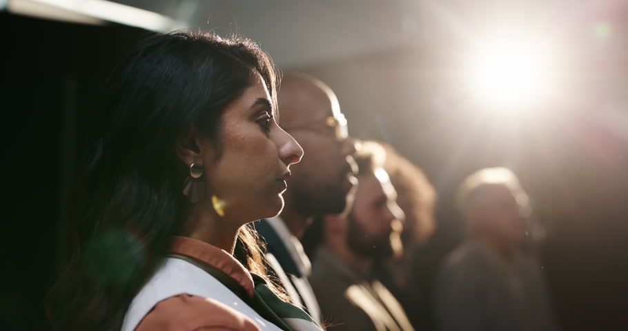 Conference, audience and business woman listen to presentation, investment workshop or training. Attention, seminar and crowd at event for speech, financial expo or learning with lens flare in dark