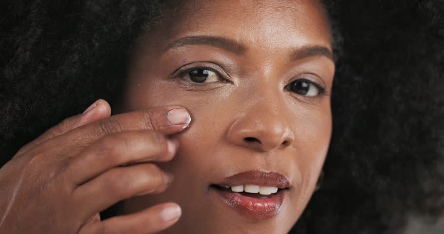 Face, black woman and smile with lotion for skincare for hydration, natural glow and facial treatment. Portrait, female person and afro with creme, dermatology benefits and smooth skin for wellness