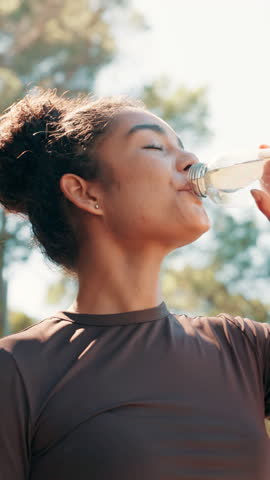Nature, woman and fitness with water to drink, nutrition or break for running challenge. Low angle, female person and runner with thirst for H2O liquid, hydration or wellness after workout outdoor