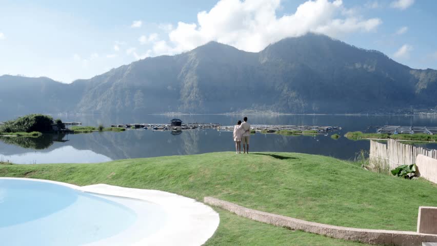 Couple Enjoying Scenic Lake and Hillside View by the Pool in 4K