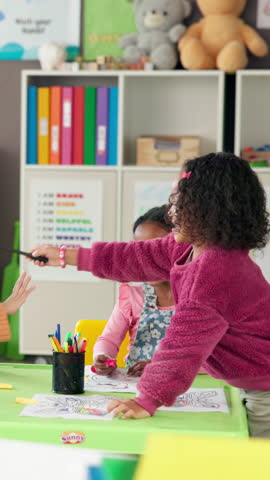 Happy children, drawing and playing in classroom for learning, education or childhood development. Group, students or elementary kids coloring with paper, chaos or disruption on table at school