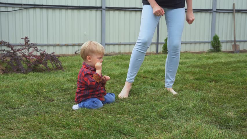 The child with his mother learns to walk