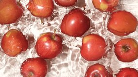Whole red apples falling into water, splash water, slow motion. - Powered by Shutterstock - Get 15% off with code: PIKWIZARD15