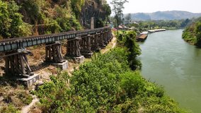Wooden railway bridge along scenic river kwai, tracing historic Burma railway path through lush tropical landscape in Banchanaburi, Thailand - Powered by Shutterstock - Get 15% off with code: PIKWIZARD15