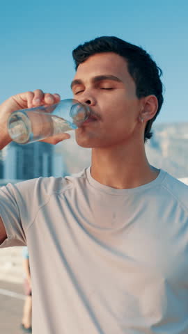 Drinking water, break and man for exercise, training and runner health for cardio or marathon in city. Hydration, athlete and challenge with energy in street for sports fitness, workout and wellness