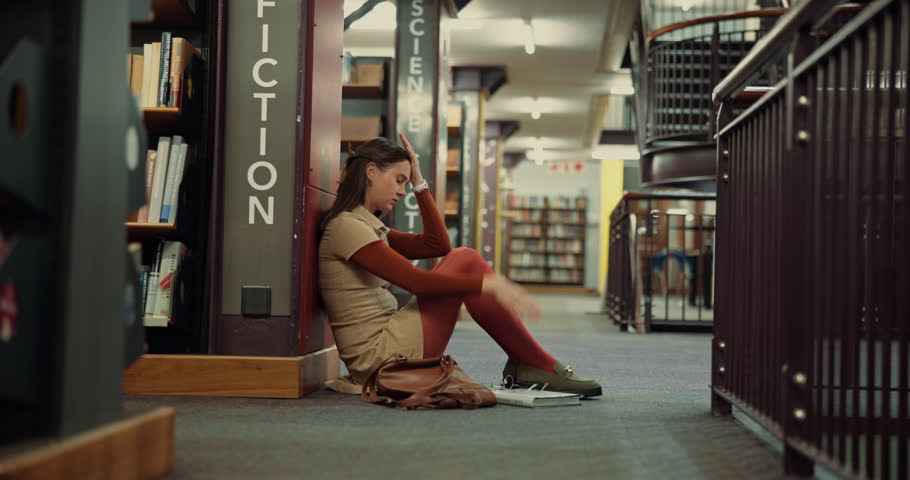Stress, student burnout and woman in library for test fail, depression and study fatigue in college. University, sad and unhappy girl overwhelmed with assignment deadline, tired and doubt on floor