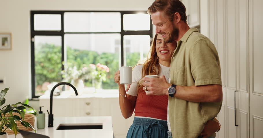 Happy, hugging and couple with coffee in kitchen for morning relax together for marriage in home. Smile, embrace and man with woman drink cappuccino for bonding, connection or relationship in house.