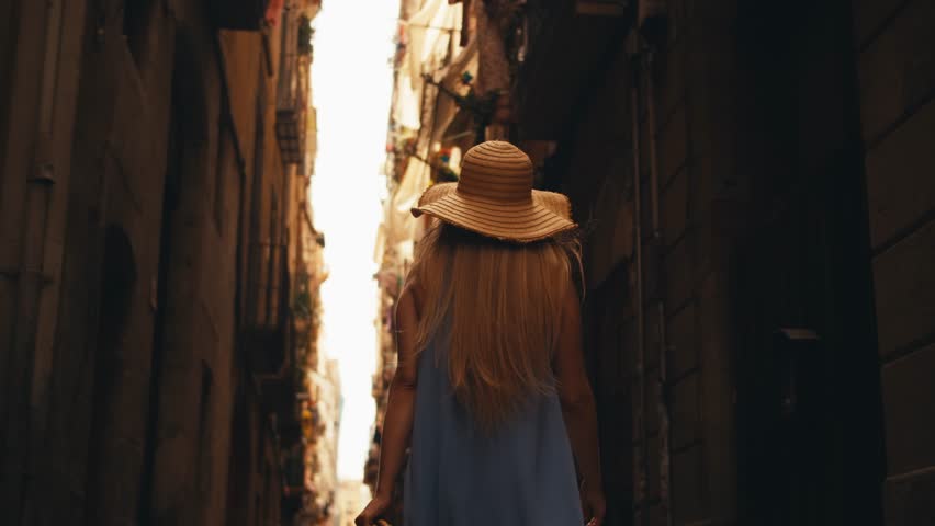 Attractive young European woman tourist with hat walking. summer center old Barcelona travel landmarks architecture vibrant city life street views tourism slow motion, 4K cinematic visual urban beauty