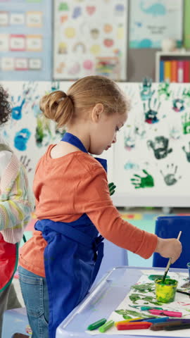 Student, kid and painting on hand in classroom for handprint activity, art project or motor skills development. Kindergarten, girl child and paintbrush for messy artwork, creative lesson or education