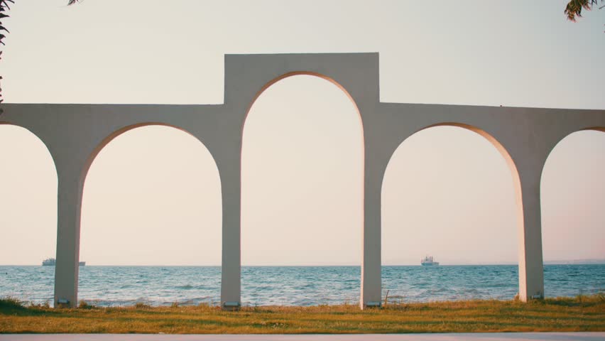 Minimalist Coastal Arch Structure Framing the Ocean Horizon at Sunset