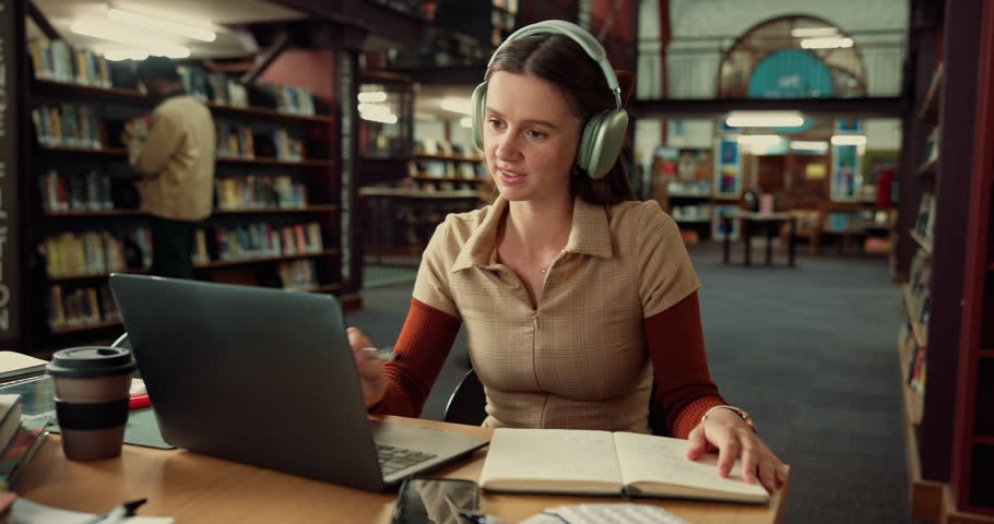 Laptop, headphones and woman student with notebook in library studying for university exam with textbooks. Education, computer and female person writing with learning for college test on campus.