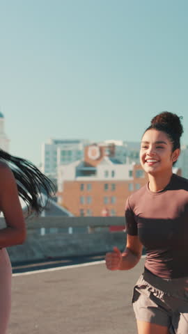 City, women and fist bump for fitness, wellness challenge and training for marathon on bridge. Outdoor, friends and running with endurance for exercise, cardio and morning jog on road with workout