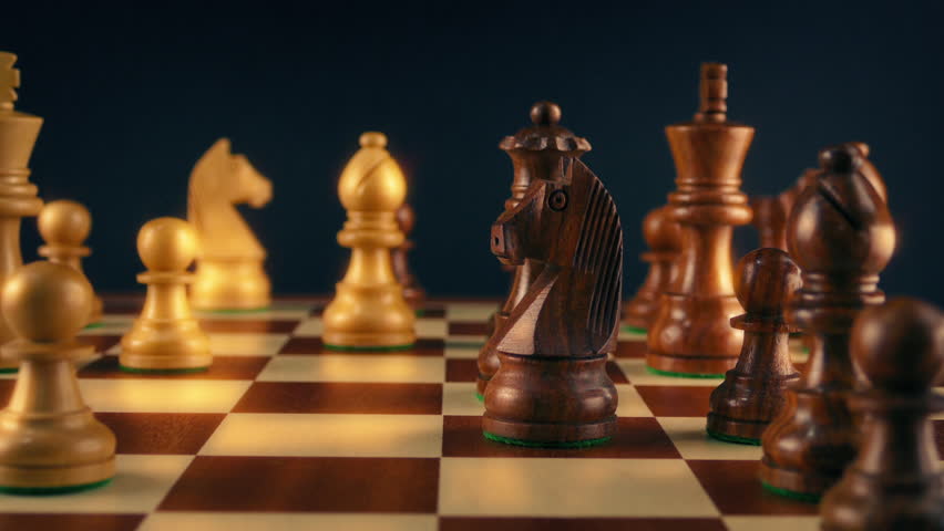 Man Moves Queen During Chess Game
