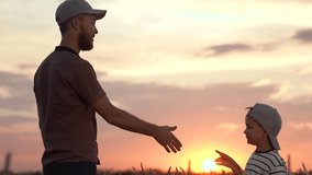Farmer father teaching son to work in field. Handshake of father son in wheat field. Agricultural business. Father farmer little son teamwork in field. Family business. Dad son working in plantation - Powered by Shutterstock - Get 15% off with code: PIKWIZARD15