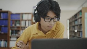 University student studying online in campus library, using laptop computer for research, homework, e-learning, project planning, reading literature, digital learning engagement. - Powered by Shutterstock - Get 15% off with code: PIKWIZARD15