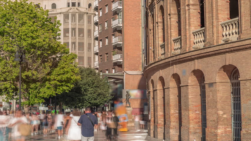 Timelapse of the Bullring of Valencia (Plaza de Bous) and Bullfighting Museum, near Nord station. People walking around the historic amphitheater with a blue sky backdrop. Valencia, Spain.