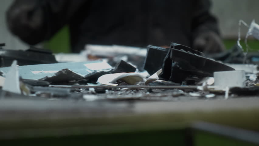 Men workers of garbage processing plant sort garbage. Male workers sort and recycle scrap metal. Plastic, polymer household waste is transported on conveyor belt in factory. Ecology of planet. Man