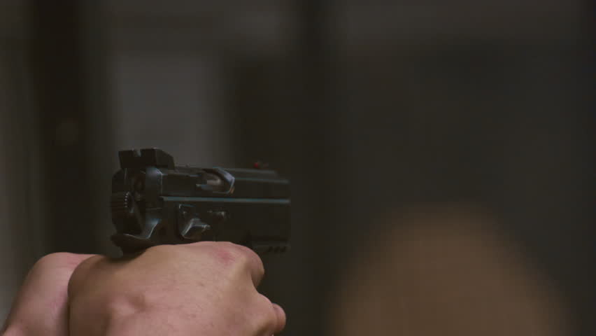 Pistol in a hand in a shooting gallery. Male makes shots in a shooting range from a weapon, slow motion. Smoke from the shot. A modern army with a Russian pistol.