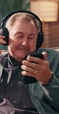 Phone, headphones and senior man home for streaming service, music and jazz playlist for freedom. Mobile, dance and happy person moving to audio and listening to radio on internet in retirement - Powered by Shutterstock - Get 15% off with code: PIKWIZARD15