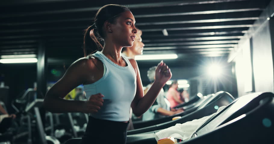 Woman, running and treadmill in gym for workout, athlete training and endurance for health. Cardio, exercise equipment or machine with female runner, intense and action for wellness at fitness center